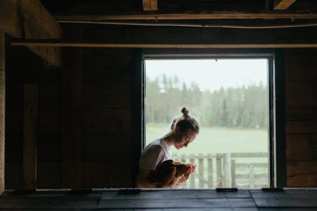 Woman cuddling with chicken at a Homestead thanks to the Homestead exemption