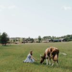 Girl enjoying cow company due to Homestead Exemption