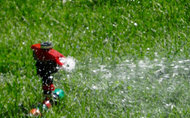 Hand-moved sprinkler irrigation on lawn