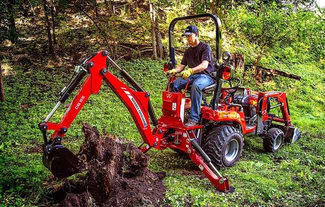 Man removing big root system on farm. Image source: Tractor.com.