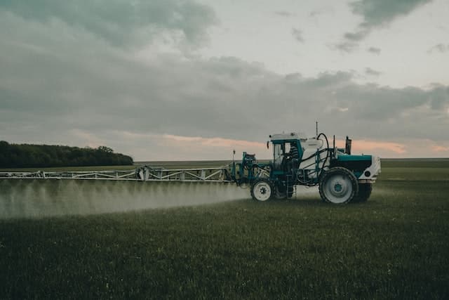 Classic traditional farming. Farmer using pesticides on his crops with a large tractor. Photo by Teo Sticea.